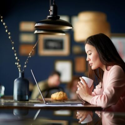 A woman enjoys a drink while virtually attending one of MBHC's behavioral health conferences.